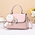 Borsa a mano rosa con trama intrecciata e ciondolo mostro di peluche bianco in studio luminoso - Rosa