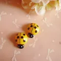 Macro detail of yellow resin ladybug charms for DIY hair clips and crafts projects - Yellow