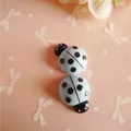 Macro detail of two light blue resin ladybug charms for DIY hair clips and phone cases - Blue