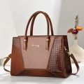 Detail of embossed crocodile texture and smooth brown leather on tote bag with gold logo - Khaki/Earth Yellow
