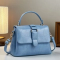 Detail of light blue crocodile-embossed handbag with gold-tone hardware and handle - Light Blue