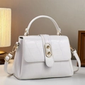 Borsa a mano bianca motivo coccodrillo con dettagli dorati e manico in contesto elegante - Bianco