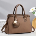 Brown woven texture tote bag with heart charm and detachable strap on studio background - Brown