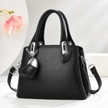 Elegant black pebble leather handbag with silver hardware and heart charm on white background - Black
