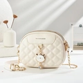 Beige quilted crossbody bag with golden chain and crystal cat pendant on white surface - Off-white