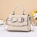 Close-up of woven texture and double leather bow detail on beige luxury crossbody bag - Off White