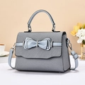 Detail of grey-blue luxury crossbody bag with layered bow and textured fabric finish - Sky Blue