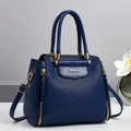 Elegant navy blue embossed quilted handbag with gold hardware and top handles - Blue