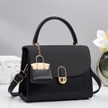 Elegant black leather handbag with woven texture flap and gold lock in a luxury setting - Black