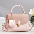 Pink crossbody handbag with woven texture flap and golden buckle on light grey background - Pink