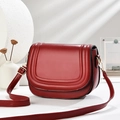 Elegante borsa a tracolla rosso vino con finiture dorate e cuciture curve su sfondo bianco - Rosso