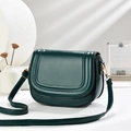 Minimalist forest green leather crossbody saddle bag with elegant gold buckle on white base - Green