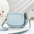 Dettaglio della borsa a sella azzurra con cuciture fini e finiture in metallo dorato - Blu