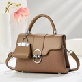 Detail view of brown leather and woven fabric textures with silver clasp and mini bag charm - Dark Khaki