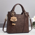 Classic vintage brown faux leather handbag with gold hardware and plush charm decoration - Coffee
