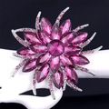 Exquisite purple crystal flower brooch on a white stand against a black background - Purple