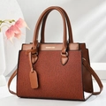 Détail de la texture plissée rouge rouille et lettrage doré sur sac à main chic - Jaune Terre