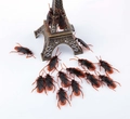 Detailed macro view of realistic prank cockroaches crawling on a small Eiffel Tower model - Simulation Cockroach