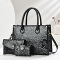 Detailed view of 3-piece bag set with black embossed floral patterns and golden hardware - Black