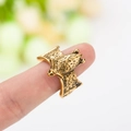 Makroaufnahme des antiken Gold-Fledermausrings mit Vintage-Textur am Finger - Antikgold