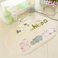 Beige oval bath mat with cartoon hippo print and non-slip surface suction cups - Transparent Hippo