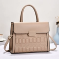 Elegant beige embossed crossbody bag with metallic clasp and adjustable strap in minimalist setting - Khaki