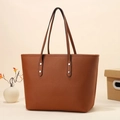 Brown lychee leather tote bag with silver rivets and long straps on a beige background - Brown