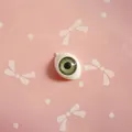 Macro shot of 10x14mm green acrylic doll eyes with realistic iris texture and oval base - Green