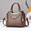 Brown vintage leather handbag with golden flamingo charm and pearl tassel accessory - Coffee