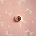 Macro detail of oval acrylic doll eye showing brown gradient iris and radial textures - Burgundy
