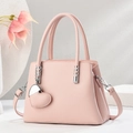 Detail of pink lychee leather tote with silver hardware and heart charm attachment - Pink