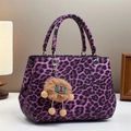 Purple leopard print leather tote bag with plush lion charm on a white surface - Purple