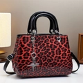 Détail du sac léopard rouge et noir avec chaîne étoile argentée et finition brillante - Rouge