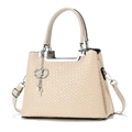 Detailansicht der cremefarbenen geflochtenen Tasche mit silbernem Griff und Anhänger - Khaki