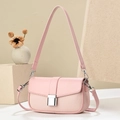 Detail of pink crossbody bag showing woven texture and silver buckle on stone stand - Pink