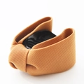 Detailed view of caramel brown bow hair clip with textured fabric and black plastic claw - Khaki
