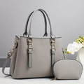 Ensemble sac à main gris texturé et petite pochette avec ferrures dorées sur fond minimaliste - Gris