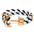 Macro detail of nautical rope bracelet featuring a polished gold-finished anchor clasp - Gold Anchor - Black White Striped Rope