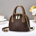 Bolso de mano retro marrón estilo vintage con cadena dorada en un ambiente de estilo de vida - café