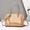 Bolso Boston caqui brillante con asas tejidas doradas y estructura de concha en fondo limpio - Caqui