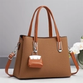 Detail van een bruine geweven shopper met een mini-tashanger en zilverkleurig beslag - Rood