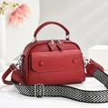 Red lychee texture leather handbag with geometric wide strap on a minimal background - Burgundy