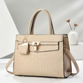Detailed macro view of beige embossed crocodile pattern with golden lock on leather handbag - Light Khaki