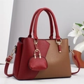 Dettaglio borsa in pelle bicolore rosso e marrone con mini ciondolo e finiture dorate - Rosso