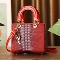 Red crocodile embossed patent leather handbag with gold charms and crossbody strap - Red