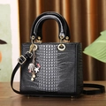 Elegant black faux crocodile skin handbag with decorative charms and top handles - Black