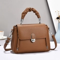 Close-up of brown lychee leather handbag with pleated handle and silver metal hardware - Earthy Yellow