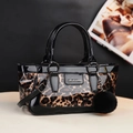 Leopard print crossbody handbag with black patent leather trim and plush pompom charm - Brown
