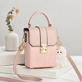 Pink snake texture square crossbody bag with metal handle and plush charm on stone background - Pink