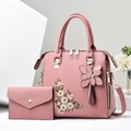 Close-up of pink pillow handbag with white daisy embroidery and matching floral charm - Pink